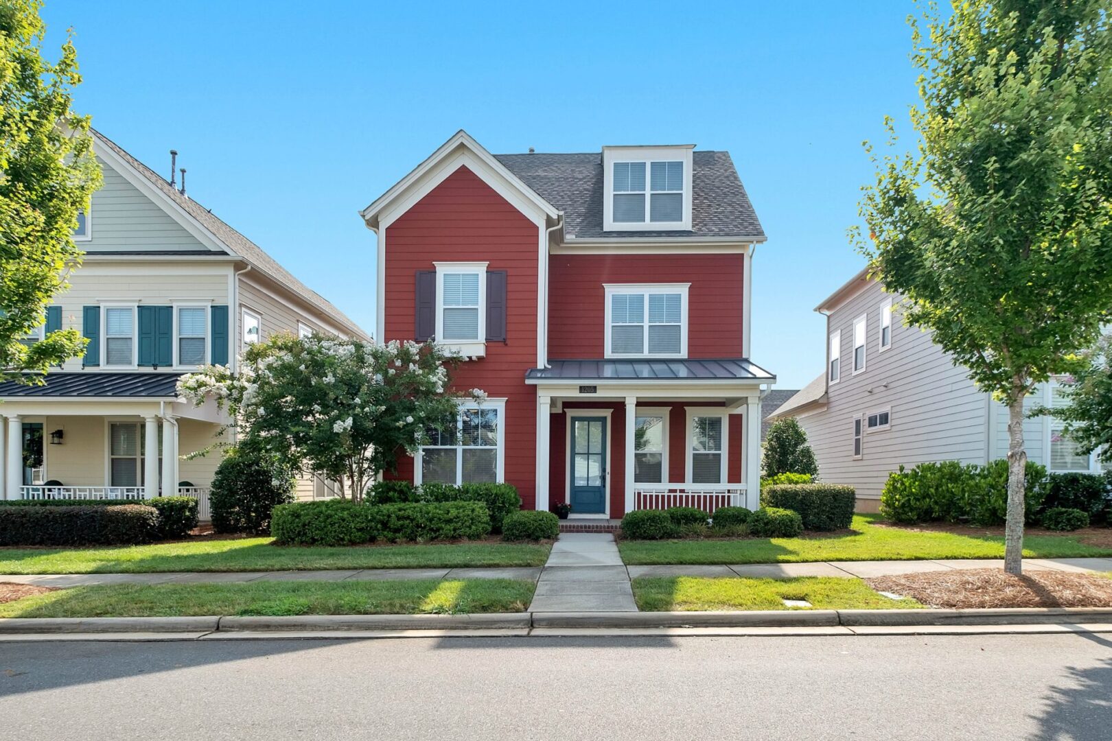 A red house with a blue door and white trim.